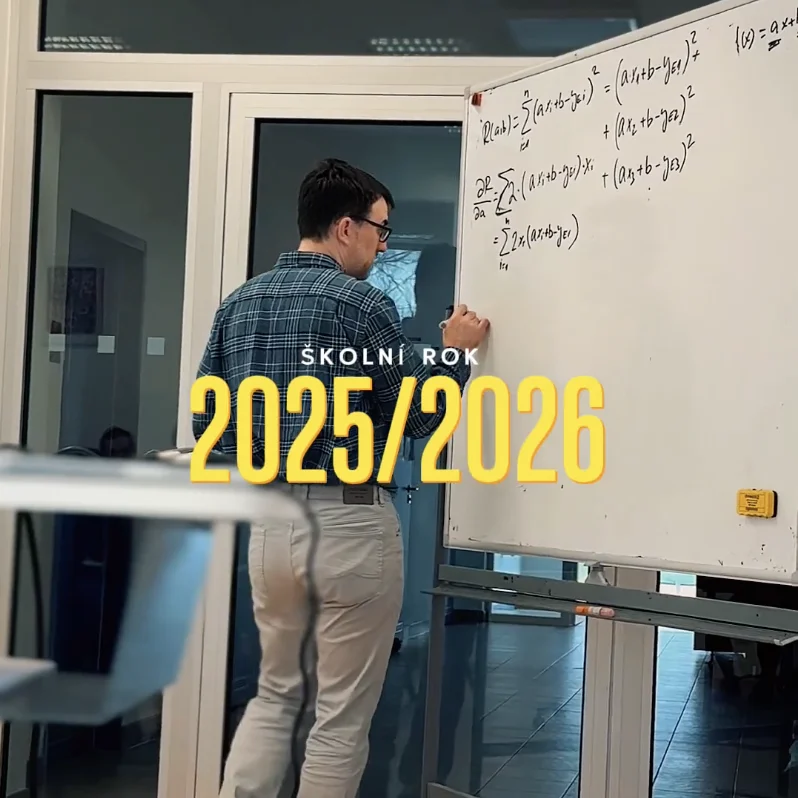 Učitel u tabule s nápisem Školní rok 2025/2026.