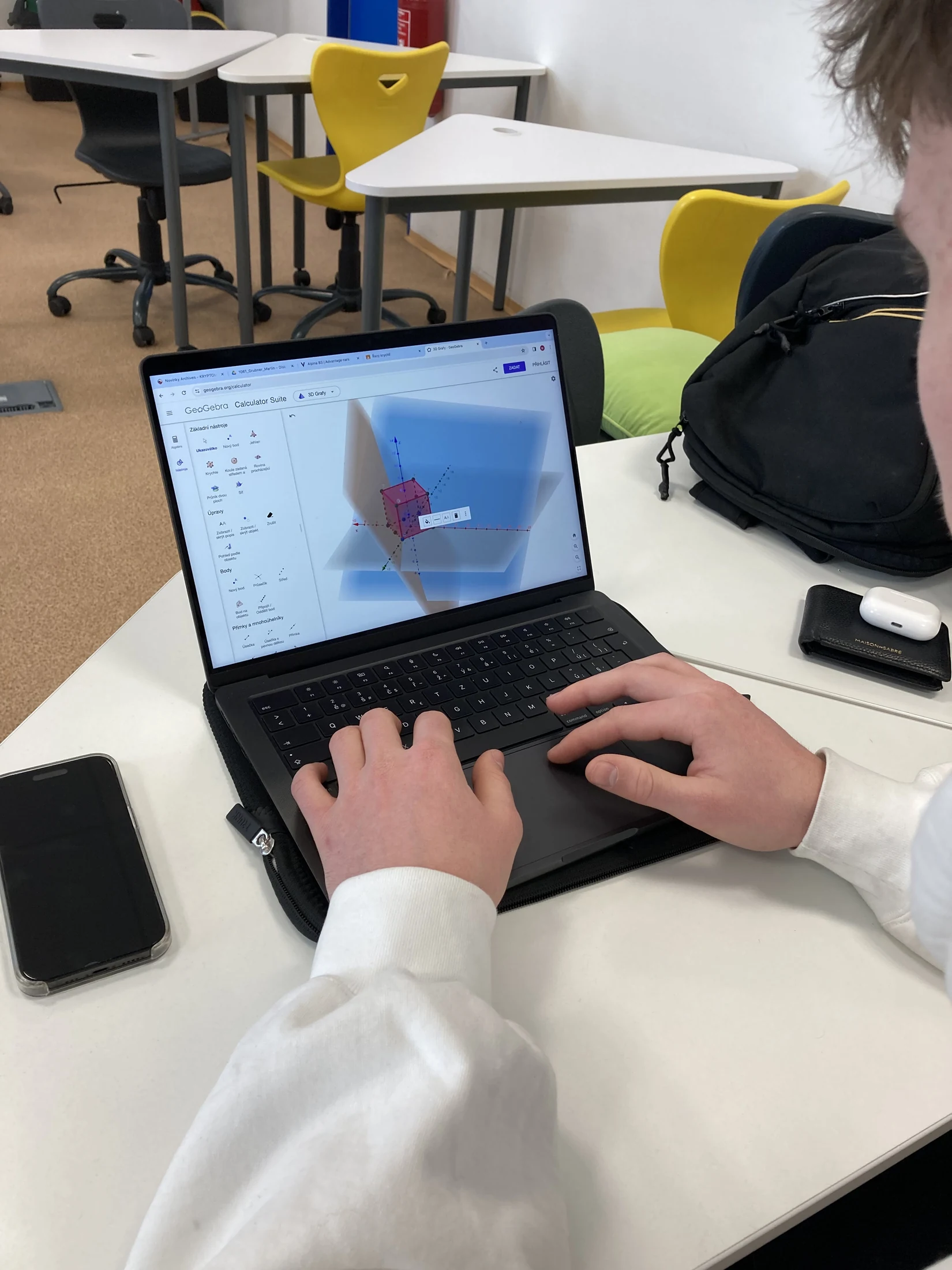 A student working with geometry on a laptop